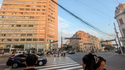a group of people crossing a street at a crosswalk at Amplia habitación en centro de Lima in Lima