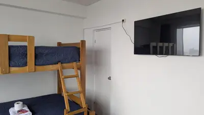 a bedroom with two bunk beds and a mirror at Amplia habitación en centro de Lima in Lima