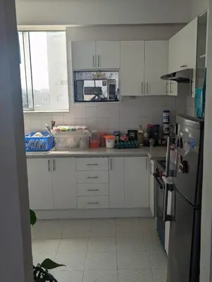 a kitchen with white cabinets and a refrigerator at Amplia habitación en centro de Lima in Lima