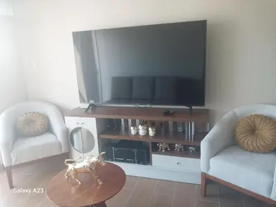 a living room with a tv and two chairs and a table at Moderno departamento con vista panorámica cerca a los centros comerciales in Lima