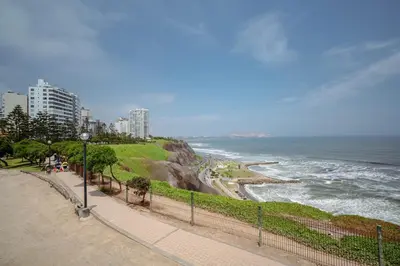 a beach with a fence next to the ocean at Manuel Tovar Apartment in Miraflores 1 BDR in Lima