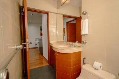 a bathroom with a sink and a toilet and a mirror at Manuel Tovar Apartment in Miraflores 1 BDR in Lima