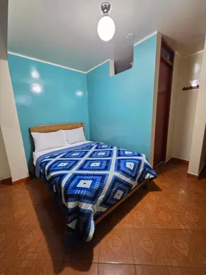 a blue bedroom with a bed with a blue wall at Hospedaje Leo in Lima