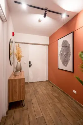 an empty hallway with orange walls and a table at Wonderland 2BR by Geko in Lima