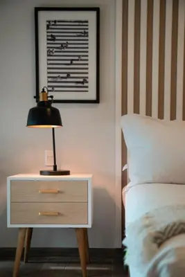 a lamp on a night stand next to a bed at Wonderland 2BR by Geko in Lima