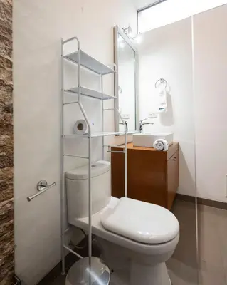 a bathroom with a toilet and a sink and a mirror at Dopamine Duplex by Geko in Lima