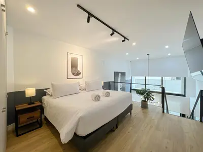a bedroom with a large bed with white sheets at Francia by Geko in Lima