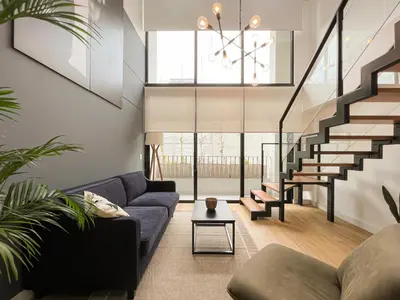 a living room with a blue couch and stairs at Francia by Geko in Lima