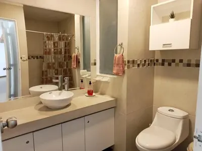 a bathroom with a toilet and a sink and a mirror at Alquilo Departamento en Playa Pulpos in Lurín