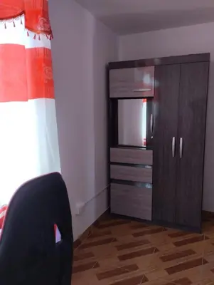 a bedroom with a dresser with a television and a chair at Acogedora casa en ICA - PERU in Ica