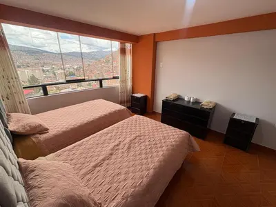 a bedroom with two beds and a large window at Nido Cusqueño in Cusco