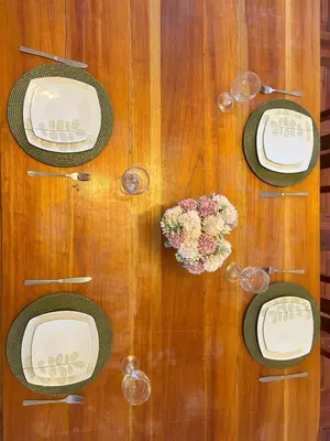 a wooden table with plates and glasses on it at Casa Raíz Cusco in Cusco