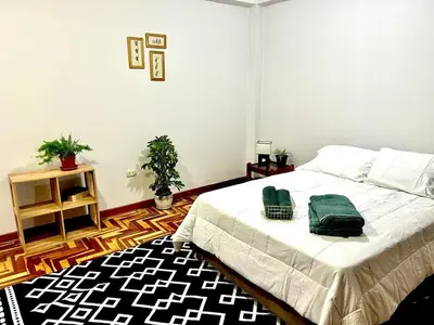 a bedroom with a bed with green towels on it at Casa Raíz Cusco in Cusco