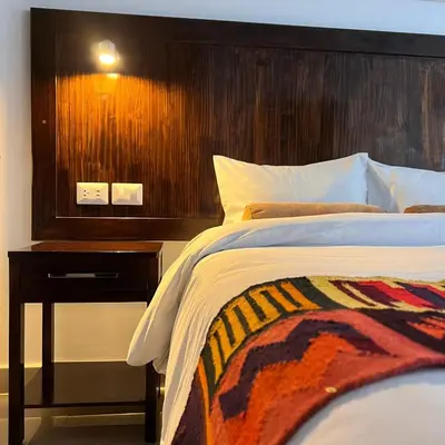 a bedroom with a bed with a wooden head board at Hospedaje Turístico - Kantu Inn in Ollantaytambo