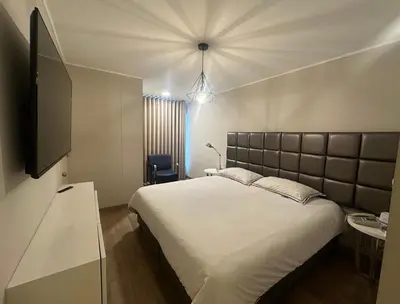 a bedroom with a large white bed and a lamp at Pardo Miraflores Apartment - Aparts 4 Days in Lima