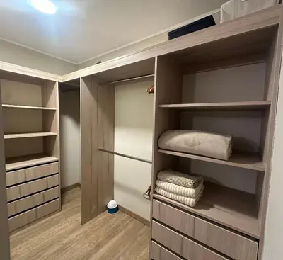 a walk in closet with wooden shelving and shelves at Pardo Miraflores Apartment - Aparts 4 Days in Lima