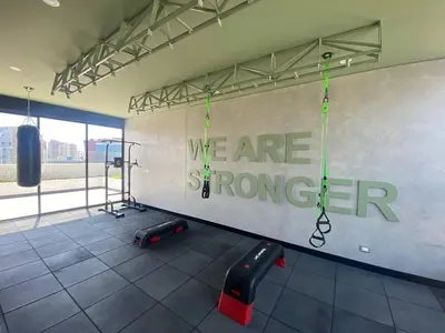 a gym with a wall with the words we are stronger at Los Pinos by Geko in Lima