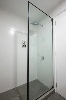 a shower with a glass door in a bathroom at Los Pinos by Geko in Lima