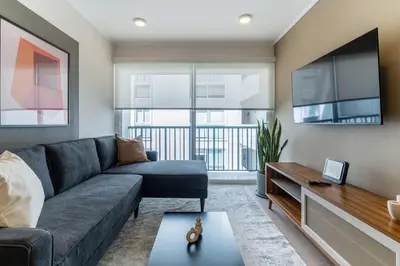 a living room with a couch and a tv at Samoa 1BR by Geko in Lima