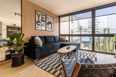 a living room with a blue couch and a table at Vince City 1BR by Geko in Lima