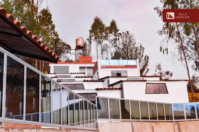 a white house with a staircase leading up to it at Villa Hidalgo - Centro Vacacional in Pazos