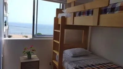 a bedroom with a bunk bed with a view of the ocean at Apartamento en San Miguel hermosa vista al mar in Lima