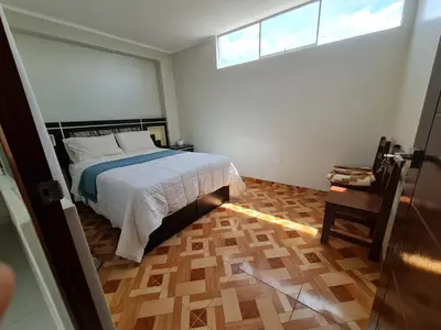 a bedroom with a bed and a window and a wooden floor at apartment MAGIC in Ayacucho