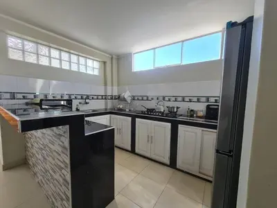 a large kitchen with white cabinets and a large window at apartment MAGIC in Ayacucho