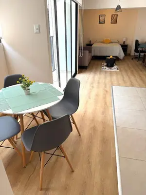 a room with a table and chairs and a bedroom at Céntrico y acogedor apartamento en Lince in Lima