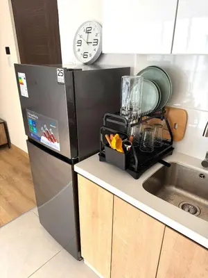 a kitchen with a refrigerator and a clock on the wall at Céntrico y acogedor apartamento en Lince in Lima