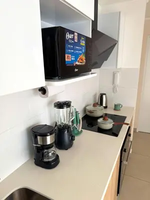 a kitchen counter with a blender and a microwave at Céntrico y acogedor apartamento en Lince in Lima