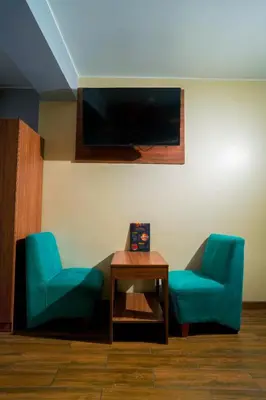 two blue chairs and a table in a room at Hotel Qhawaq Huancayo in Huancayo