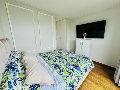 a bedroom with a bed and a tv in it at Dupli naranjos in Lima