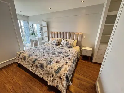a bedroom with a bed with a floral bedspread at Dupli naranjos in Lima
