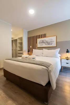 a bedroom with a large bed with white sheets and pillows at The Oak 2BR by Geko in Lima