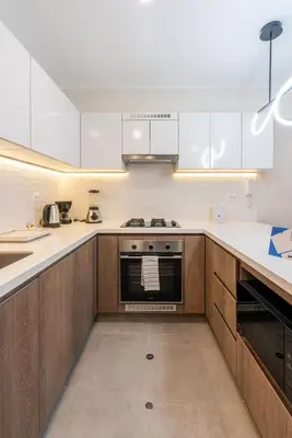 a kitchen with white counters and wooden cabinets at Audiencia by Geko in Lima