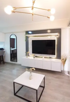 a living room with a large tv and a table at Audiencia by Geko in Lima