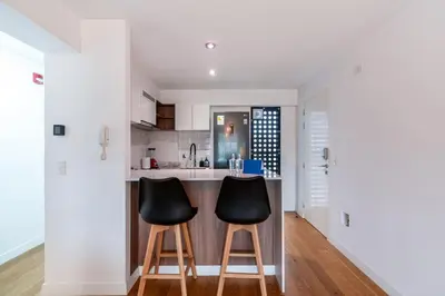 a kitchen with two black chairs at a counter at Zafira 1BR by Geko in Lima