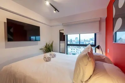 a bedroom with a white bed with two towels on it at Zafira 1BR by Geko in Lima
