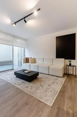 a living room with a white couch and a flat screen tv at Zebbra 1BR by Geko in Lima