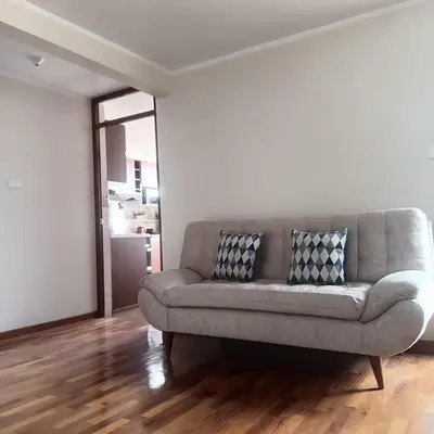 a couch sitting in a living room next to a wall at Bonito Departamento Lima Carabayllo in Lima