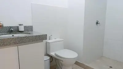 a white bathroom with a toilet and a sink at Tu mejor opción Departamento Familiar in Lima