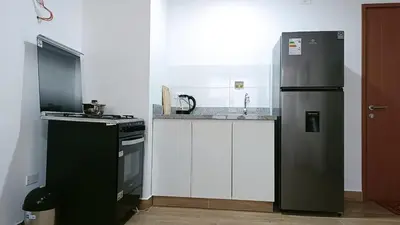 a kitchen with a black refrigerator and a stove at Tu mejor opción Departamento Familiar in Lima