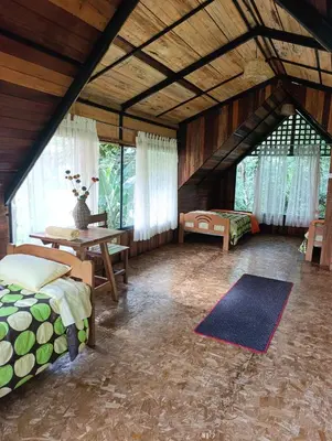a bedroom with two beds and a table in a room at Bella Victoria Ecolodge in Santa María