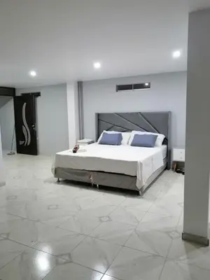 a bedroom with a large bed with blue pillows at Loft and reception RISHEL in Chincha