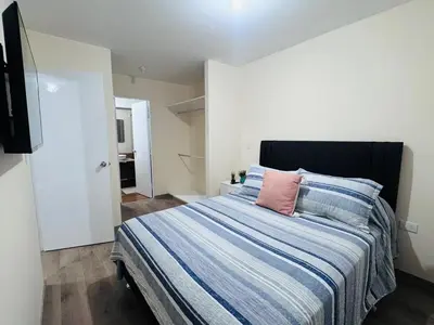 a bedroom with a bed with a blue and white striped blanket at Monterrico Polo Aparts #22- Dpto 2 Dorm 2 baños - Frente Embajada USA in Lima