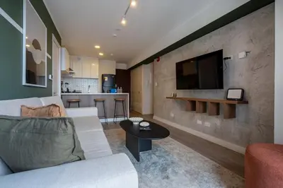 a living room with a couch and a tv on a wall at Bagheera 2BR by Geko in Lima