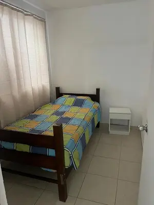a bedroom with a bed and a small table at Punta Hermosa - depa Santa Cruz in Punta Hermosa