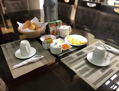 a table with plates of food and a basket of bread at B&B Cusing Wasi in Lima