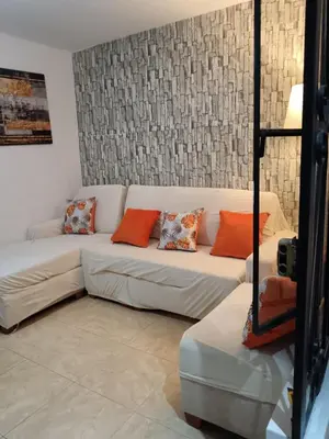 a living room with a white couch with orange pillows at Departamento Vista al Parque Coopip in Lima